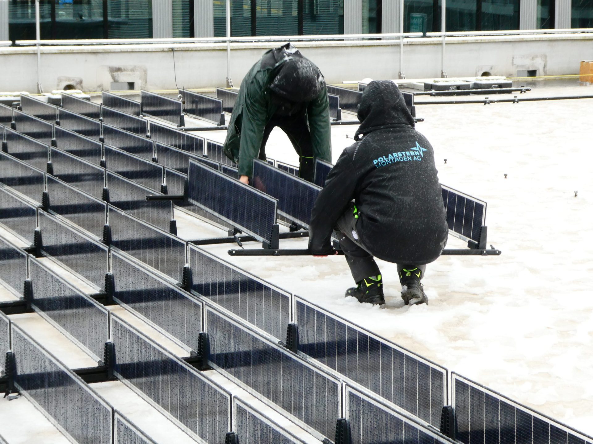 Crew setting Over Easy Solar units on a flat roof in Switzerland